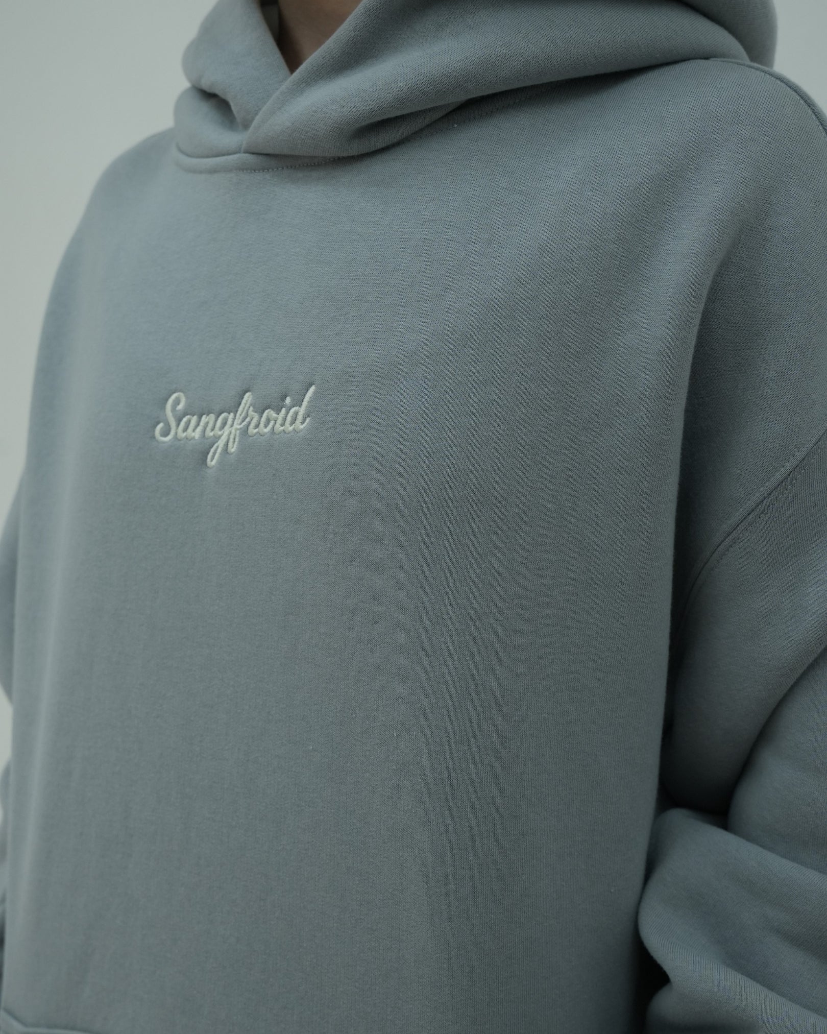Gray hoodie with 'Sangfroid' branding on a plain background