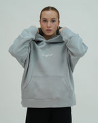 Person wearing a light gray hoodie with 'Sangfroid' branding on a plain background