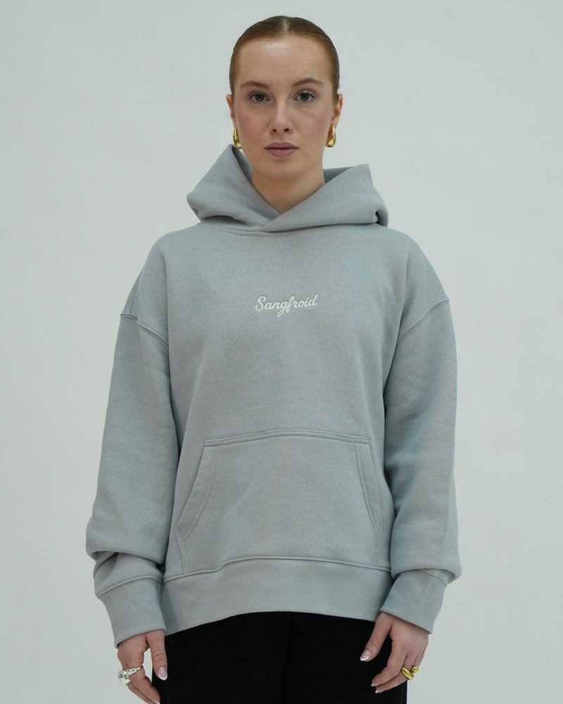 Person wearing a light gray hoodie with 'Sangfroid' branding on a plain background