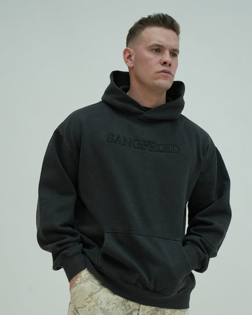 Man wearing a black hoodie with 'SANGFROID' text on a plain background