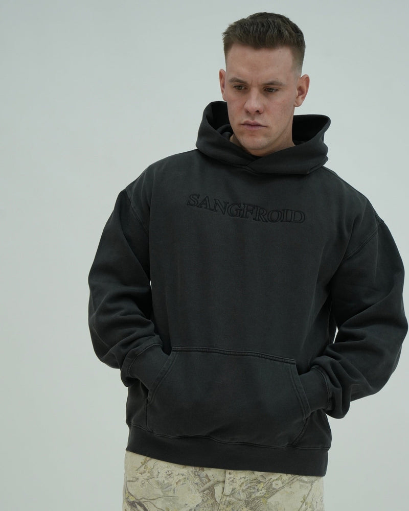 Man wearing a black hoodie with 'SANGFROID' branding on a gray background