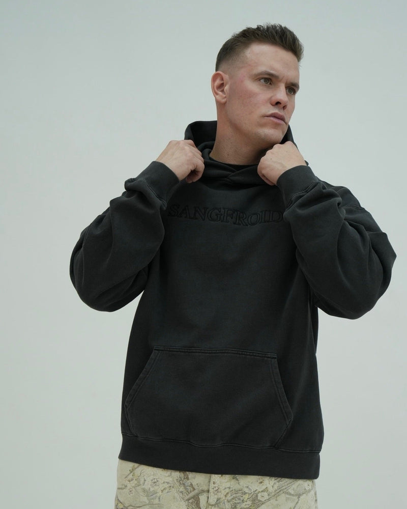 Man wearing a black hoodie with a neutral background