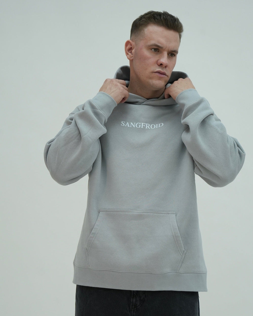 Man wearing a gray hoodie with 'SANGFROID' branding on a light gray background