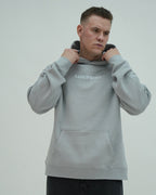 Man wearing a gray hoodie with 'SANGFROID' branding on a light gray background