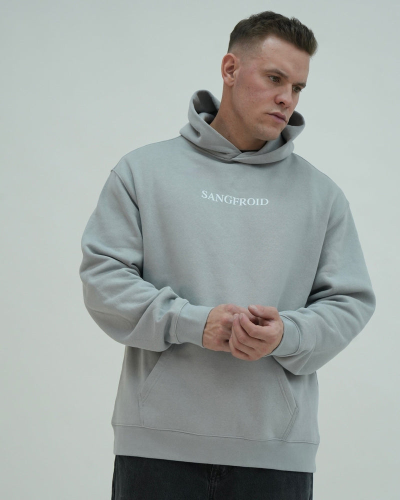 Man wearing a gray hoodie with 'SANGFROID' branding against a plain background