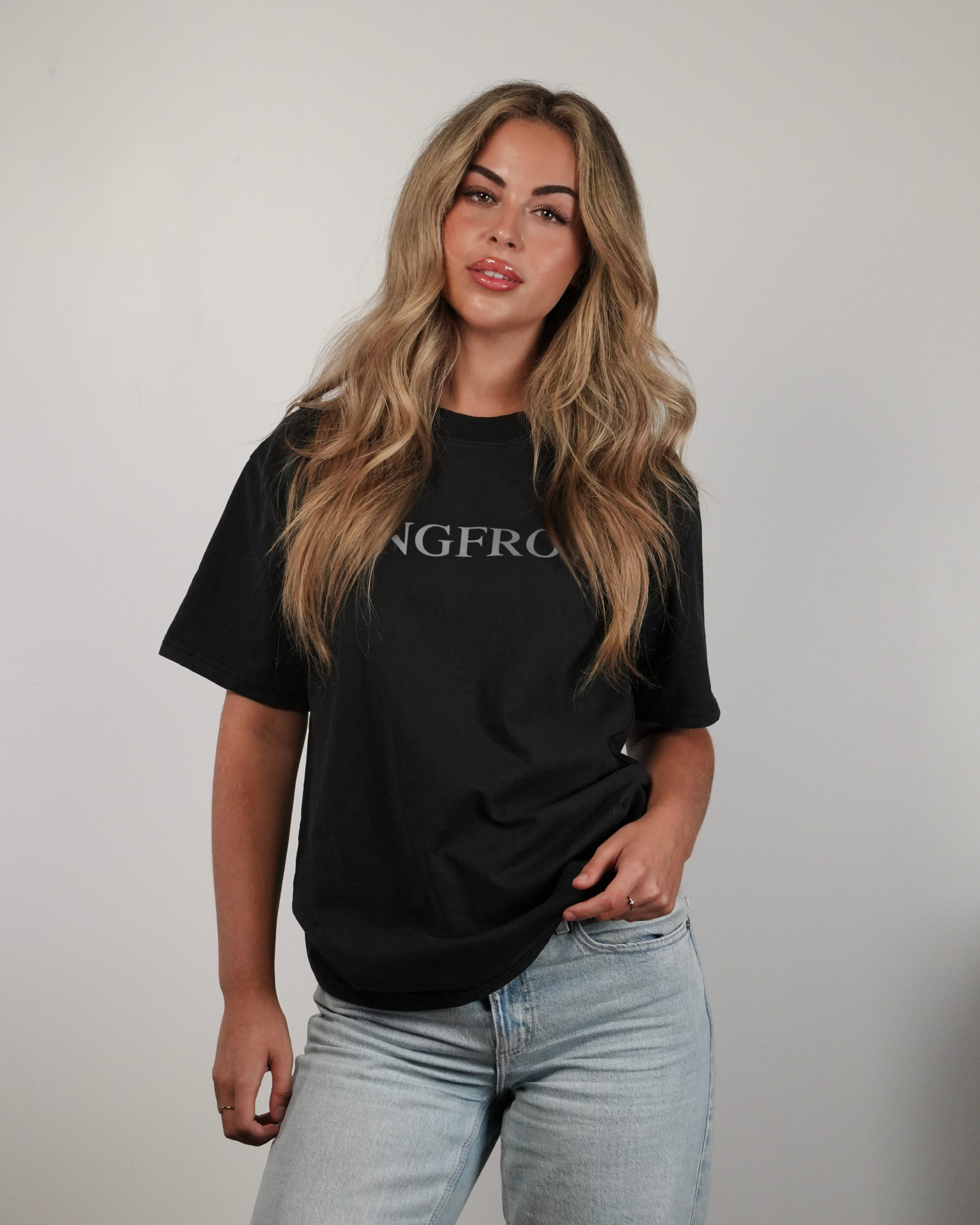 Woman wearing a black t-shirt with 'SANGFROID' logo against a plain background