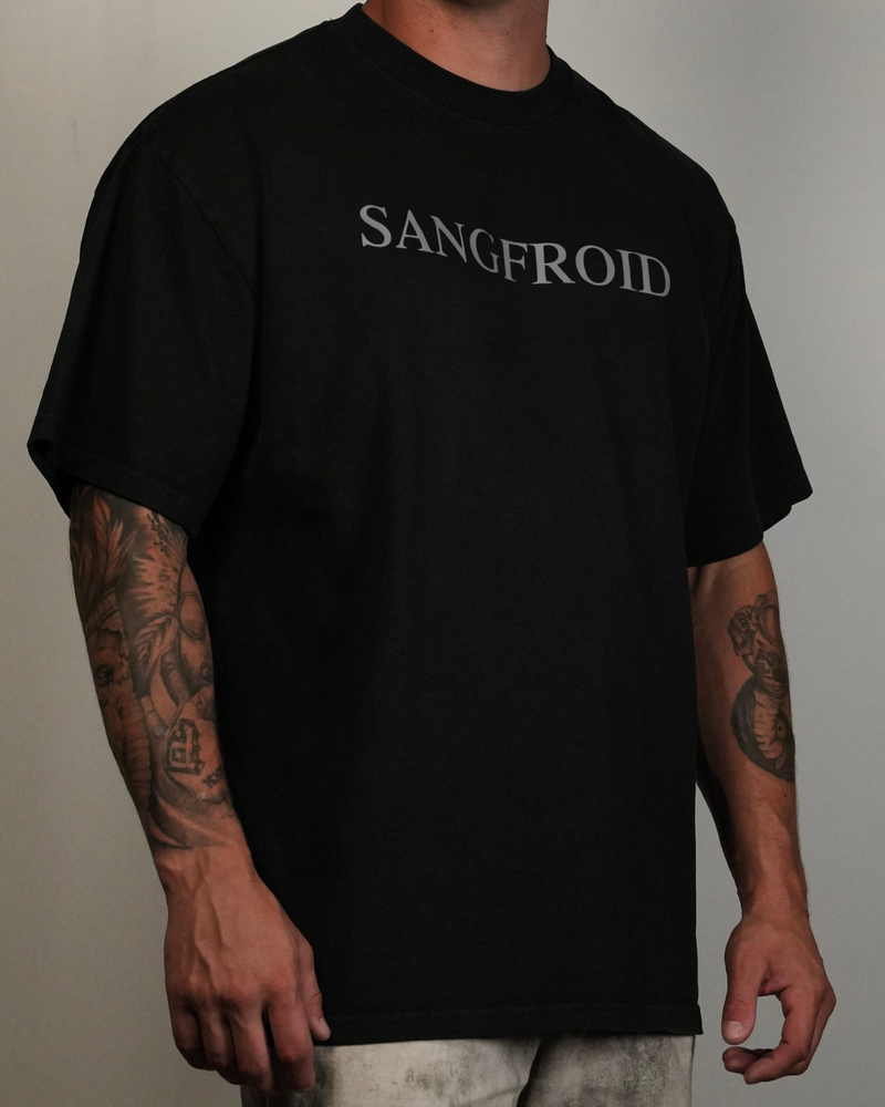 Person wearing a black t-shirt with 'SANGFROID' text on a plain background