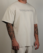 Person wearing a beige t-shirt with 'SANGFROID' text, standing against a plain background.