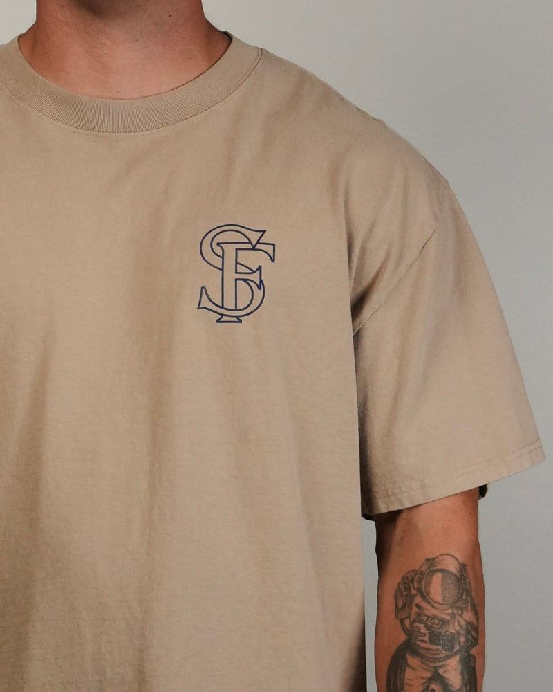 Beige t-shirt with a logo on the chest against a plain background