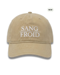 A beige washed cotton baseball cap with white embroidered text reading 'SANG FROID' on the front, shown against a plain white background with a small 'NEW' badge in the top right corner.